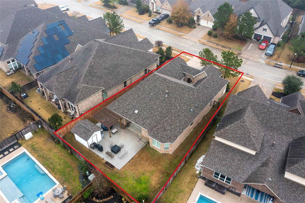 This fantastic backyard offers a large patio with a firepit, storage shed, and pergola.