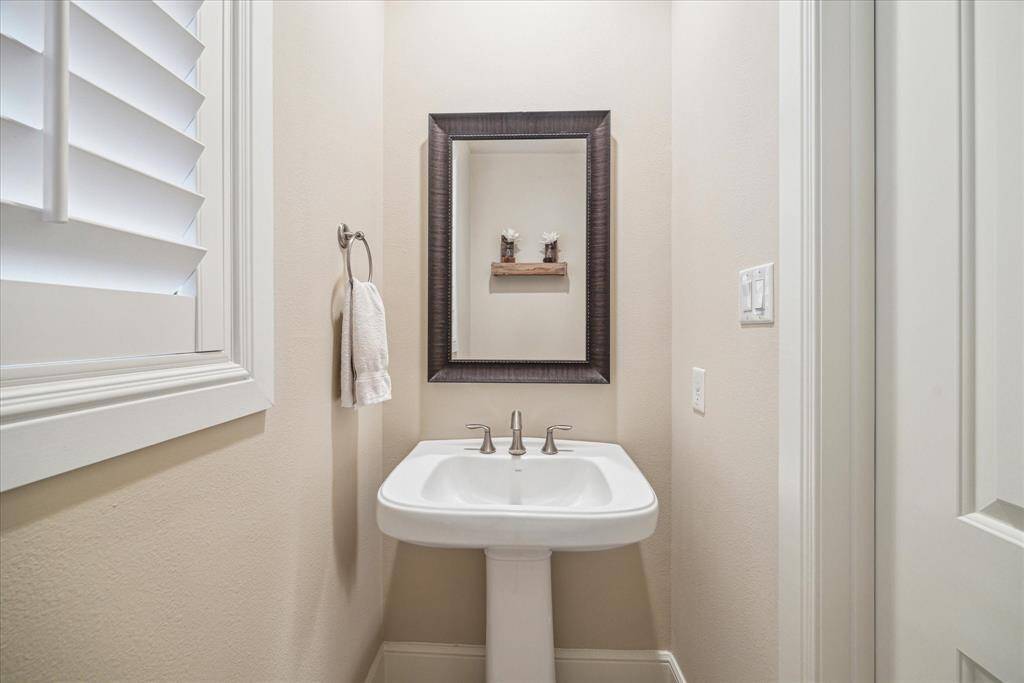 The powder room is conveniently situated between the dining room and kitchen.