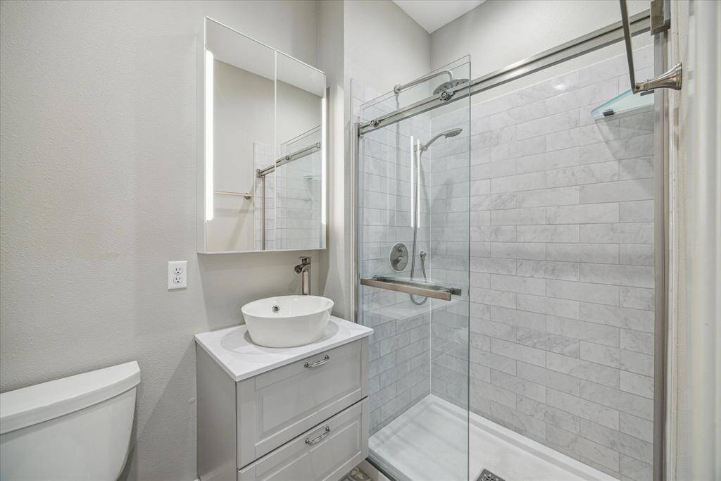 The garage apartment's full bathroom includes a shower and a vanity with a vessel sink.