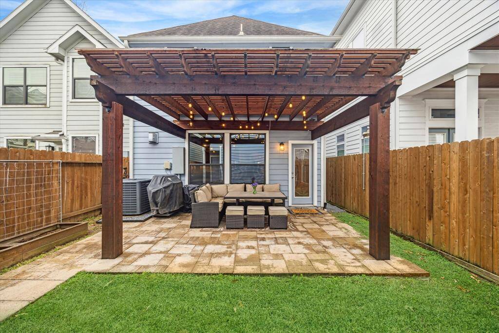 A covered pergola extends the back porch, expanding the outdoor living area, and is equipped with a gas connection for an outdoor grill.