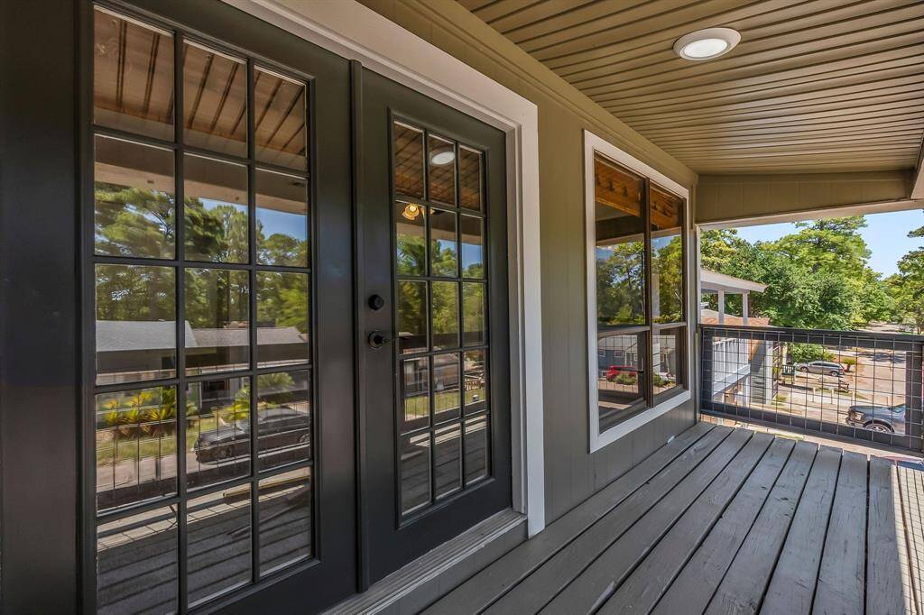French doors lead to the upstairs balcony off of the primary bedroom
