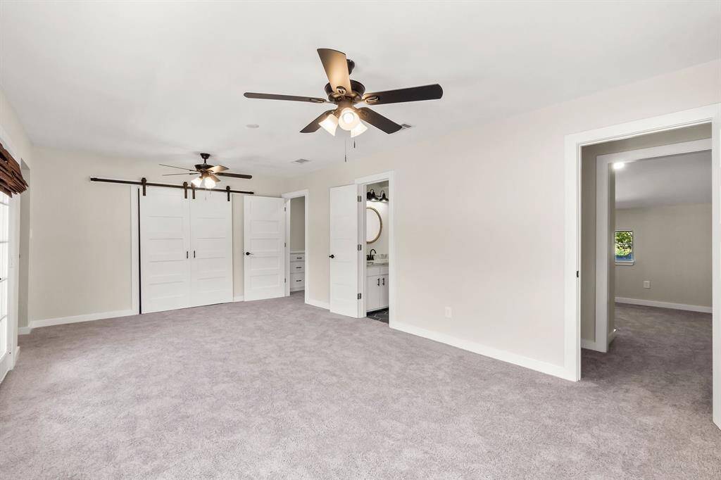 Primary bedroom has closet behind the barn doors and two bonus spaces