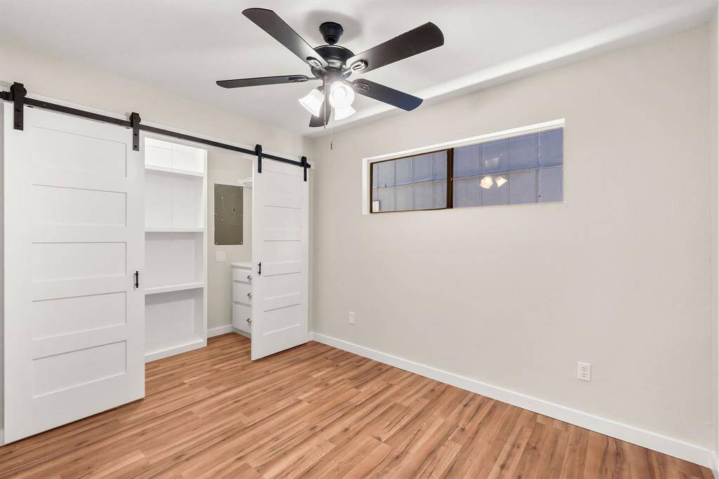 The downstairs bedroom has sliding barn doors to access the closet with built-ins