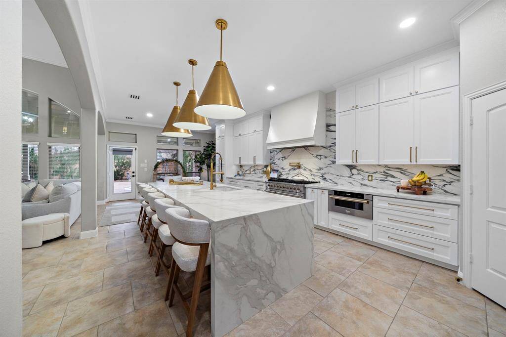 The custom 60-inch hood vent, along with a recessed 48-inch exhaust fan, ensures superior ventilation while maintaining the seamless, high-end design.