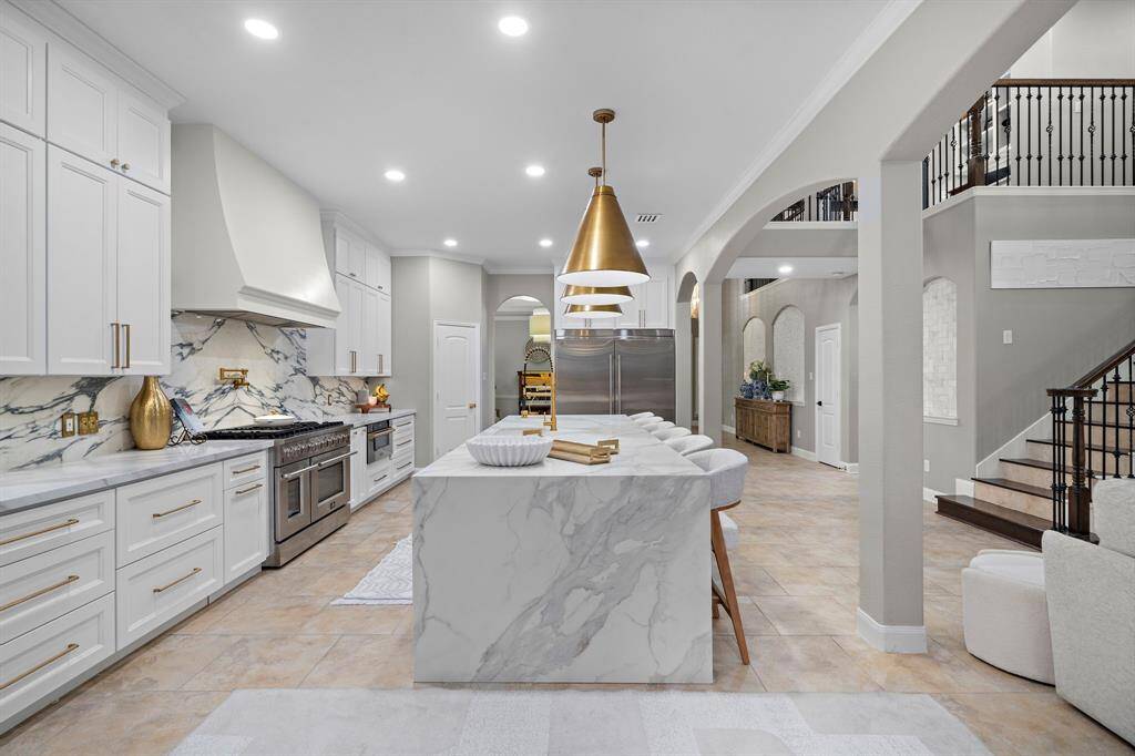 This stunning kitchen is designed for both style and functionality, featuring a show-stopping 12-foot quartz island, perfect for cooking, dining, and entertaining. The island is complemented by beautiful white oak fluted panels, subtly illuminated by recessed color-changing LED strips, creating a dynamic ambiance. Electrical outlets are thoughtfully recessed along the entire length of the island for a sleek, clutter-free look.