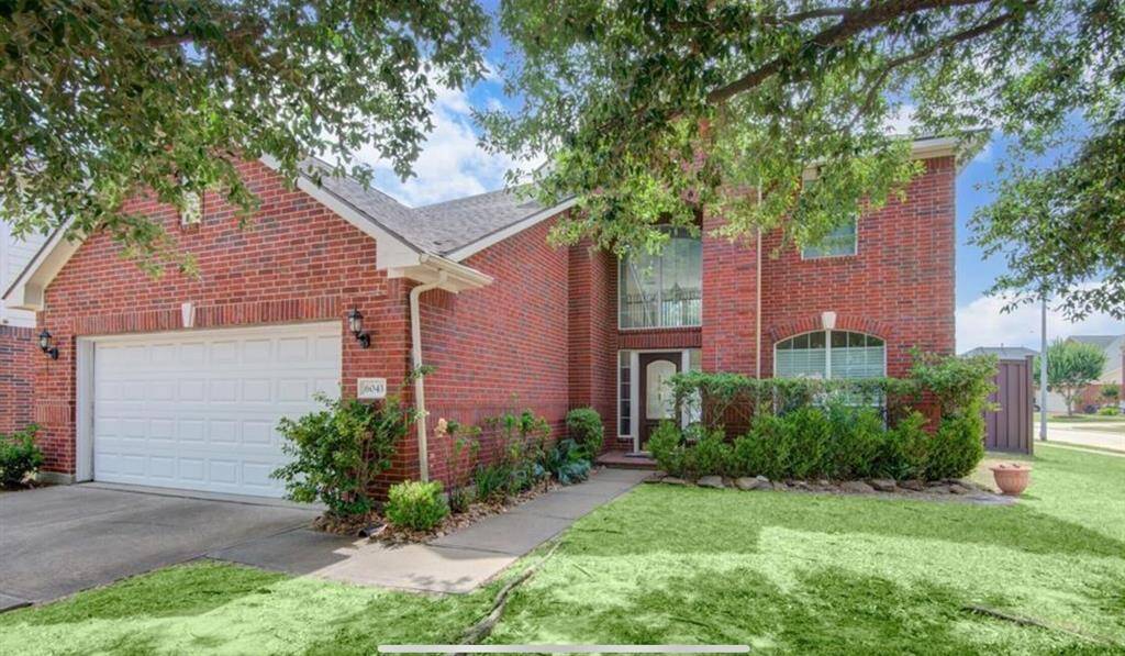 Charming 4-bedroom home with a spacious yard, elegant brick exterior, and mature trees on a quiet street.