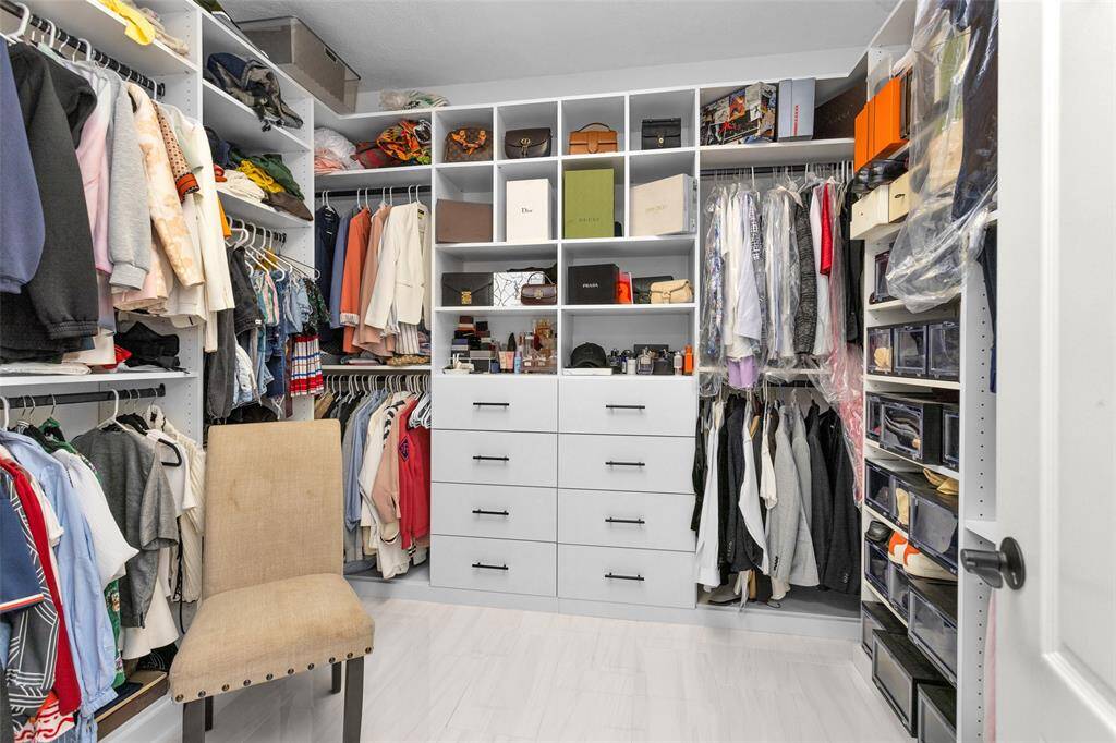 This walk-in closet is stunning with custom drawers and shelving.