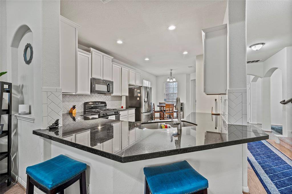 Breakfast bar seating serves as a versatile centerpiece, providing additional workspace, storage, and seating for casual dining or entertaining.
