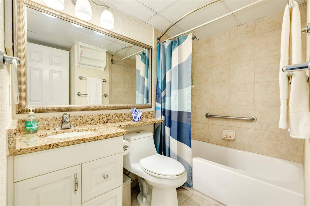 Hall entrance to bathroom.  Has tub with tiled shower and granite counters.