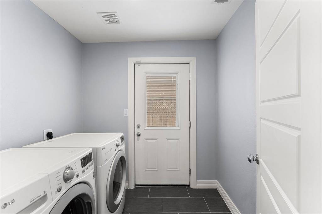 Laundry on the first floor with the door to the backyard.  Washer and dryer stay.