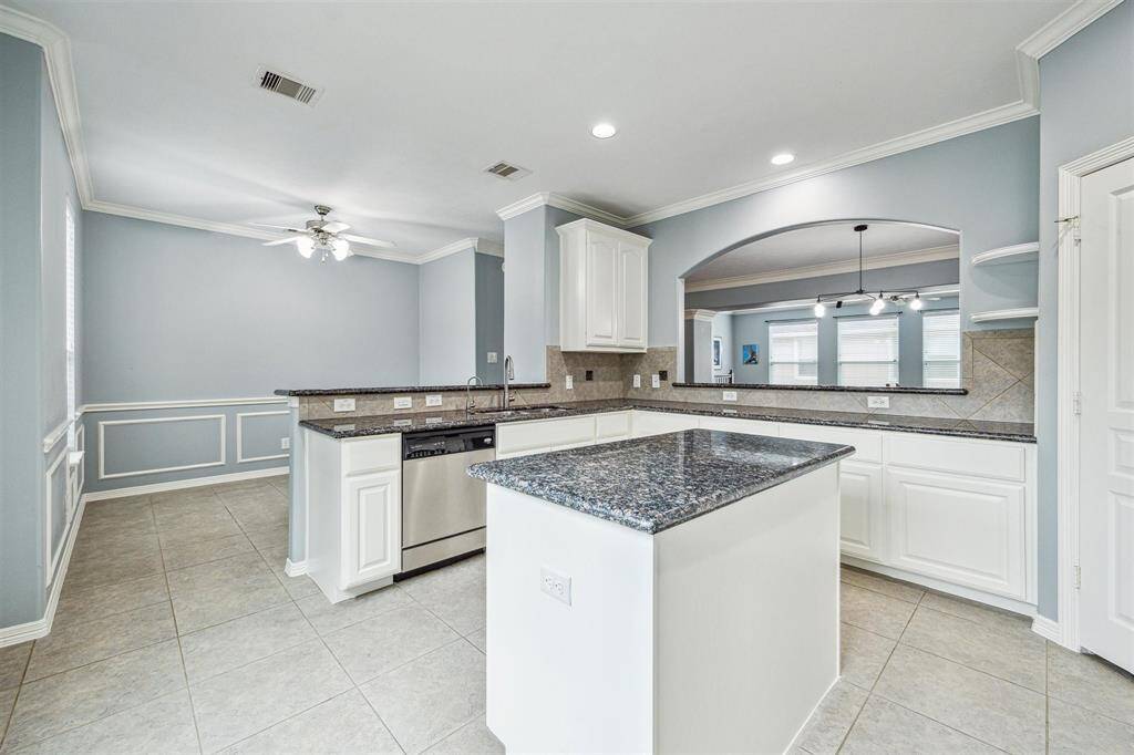 Kitchen with granite countertops, stainless steel appliances, gas cooktop, and a breakfast bar.