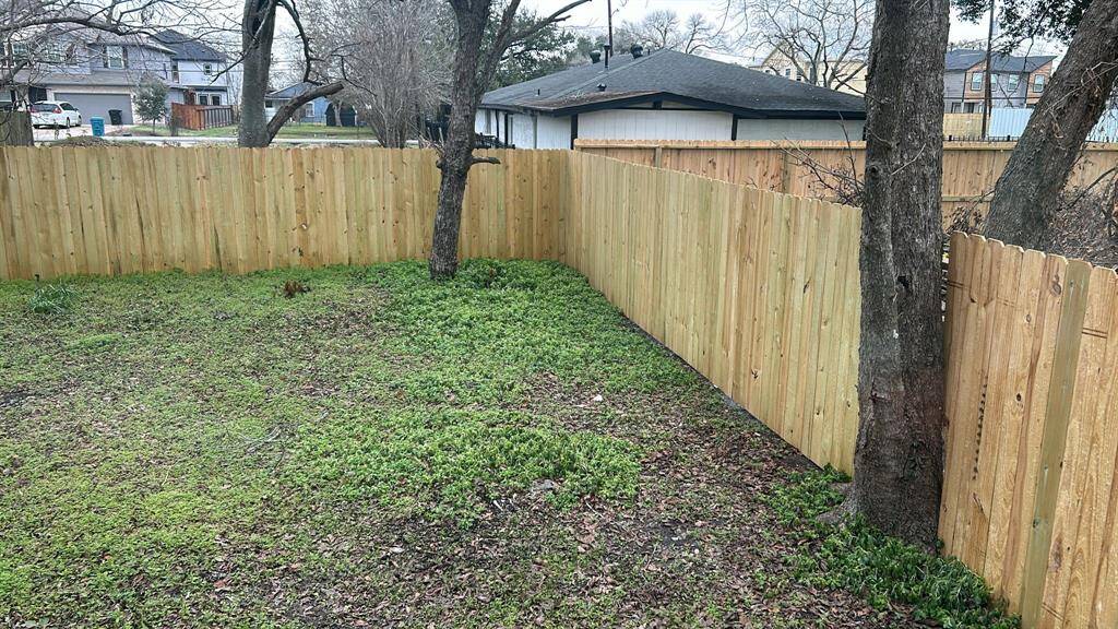 New fence enclosing the entire backyard, providing privacy and security.