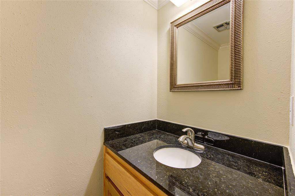 Chic and functional powder room with elegant granite countertop and stylish fixtures.