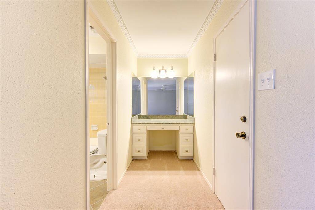 Elegant vanity area in the primary bedroom, featuring ample storage and bright lighting.