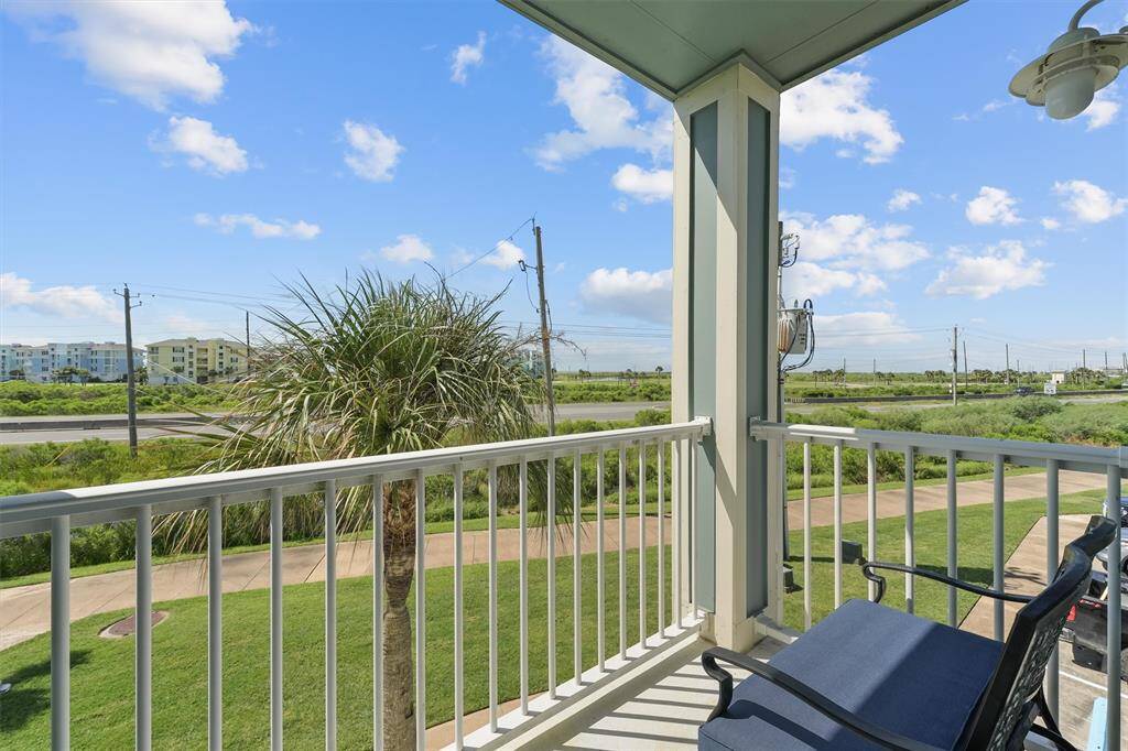 The balcony off the primary bedroom offers a relaxing outdoor space with a scenic view of lush greenery. Enjoy the fresh air and beautiful weather from this cozy spot, perfect for morning coffee or evening relaxation.