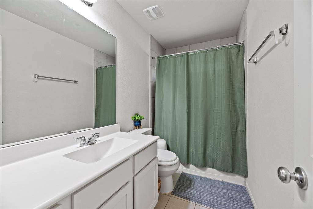 The upstairs secondary bath is spacious and comfortable, with a large vanity and ample cabinet storage.