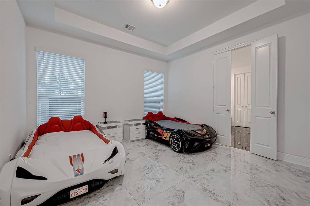Two Lavish Primary Suites on the Main Level. Pictured is the 2nd Primary Suite: Tile flooring and tray ceilings.