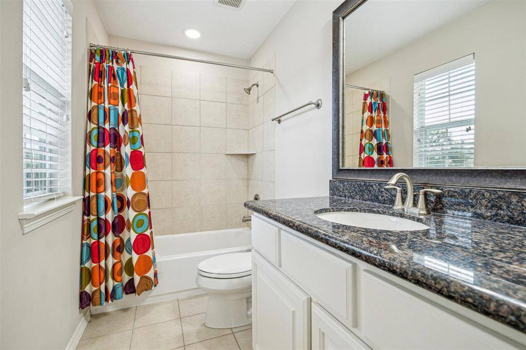 Secondary bathroom with tile floors, recessed lighting, granite counter top and a tub/shower combo.