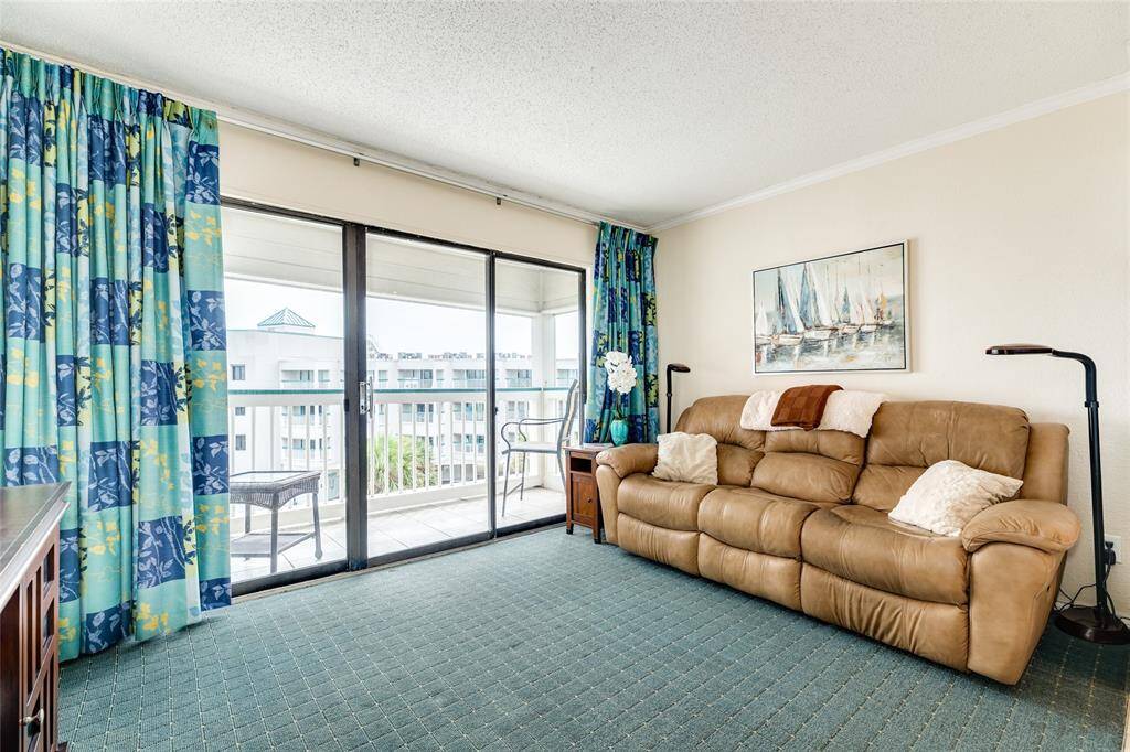 Spacious living area with wall to wall windows. Also has recently installed storm shutters.