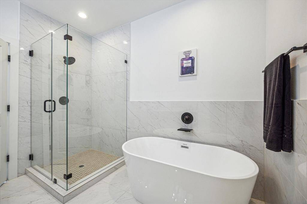 The space is elegantly finished with oversized 24x28 Daltile Marble Attache Lavish Rectangle Floor and Wall Tiles, offering a luxurious yet durable surface.