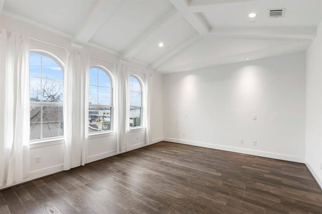 Gorgeous, vaulted ceilings and large windows make this primary bedroom feel open and airy.
