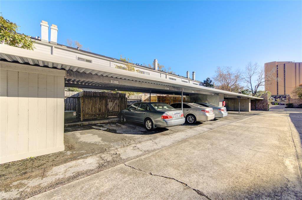 This photo shows a covered parking area with two spaces and a storage room.