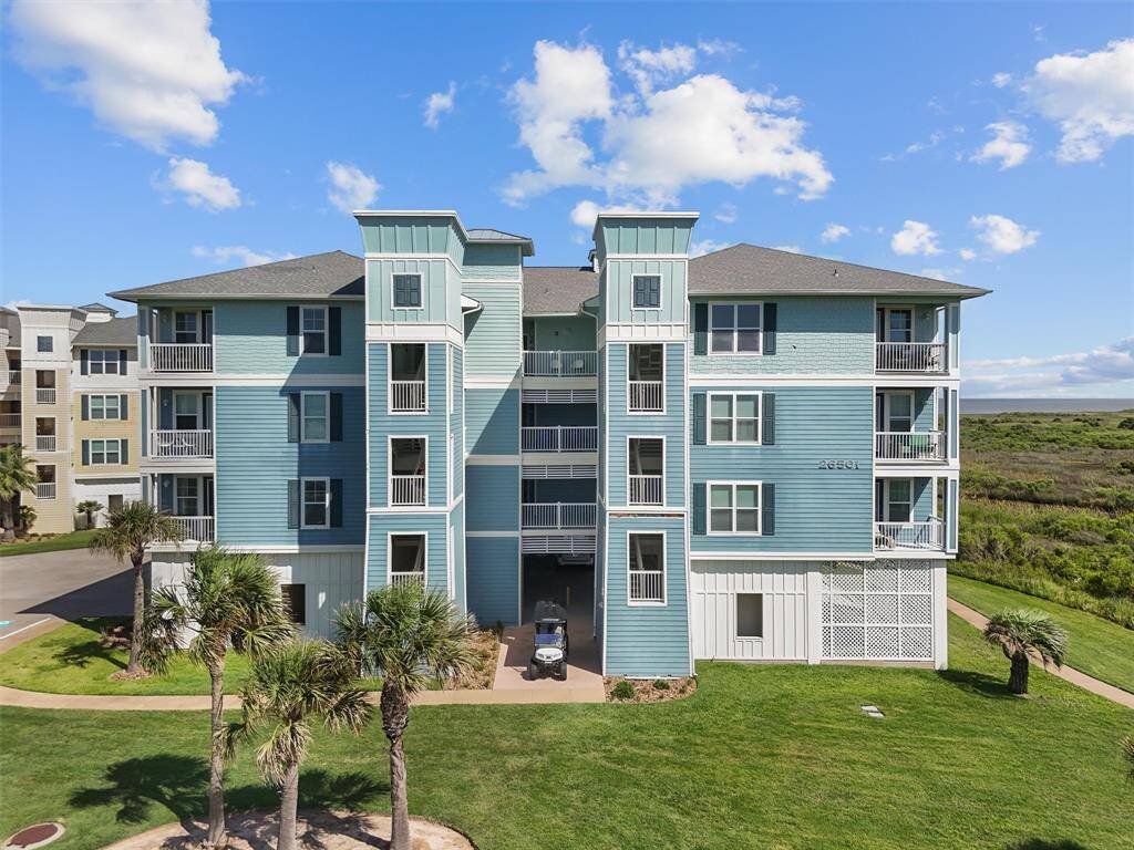 This condo at Pointe West features a modern, multi-story design offering beautiful views. The well-kept grounds include lush lawns and palm trees, creating a tropical ambiance.