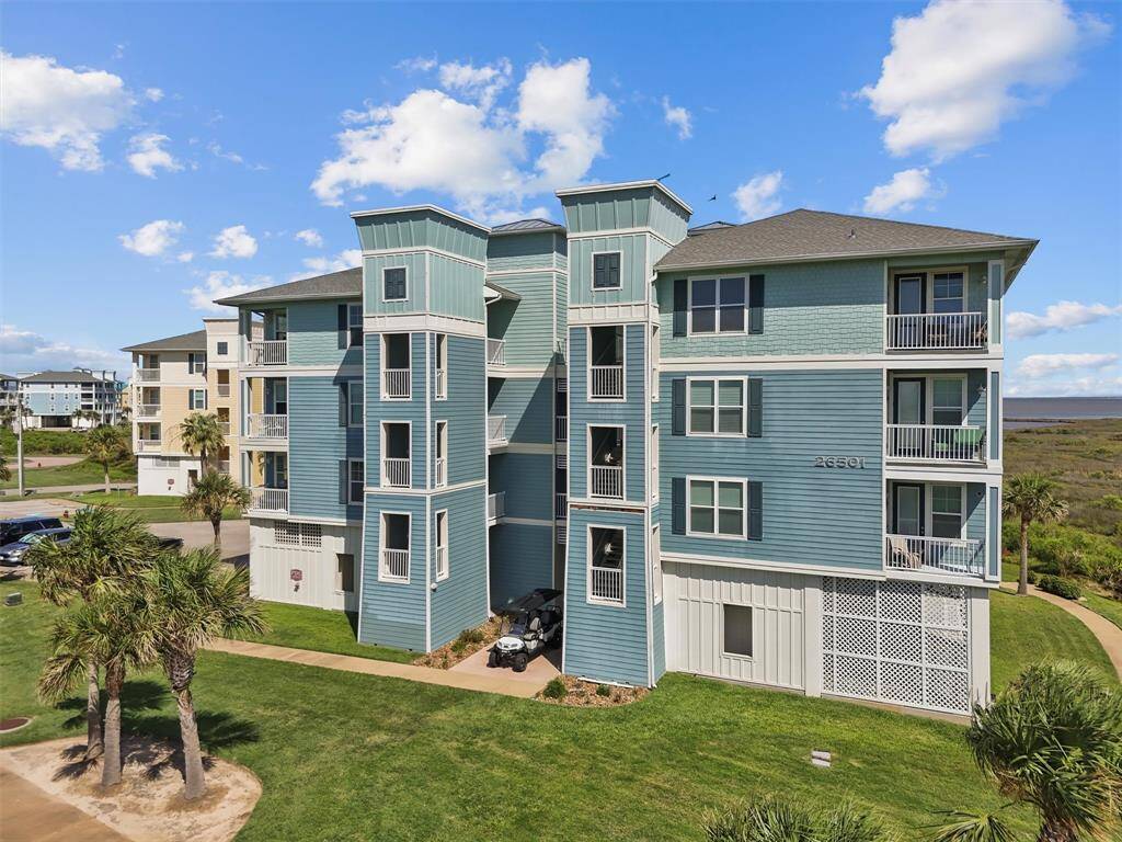 Another perspective of the condo building at Pointe West reveals its serene location near the water. The building's architecture is complemented by the picturesque natural surroundings, providing a peaceful living environment.