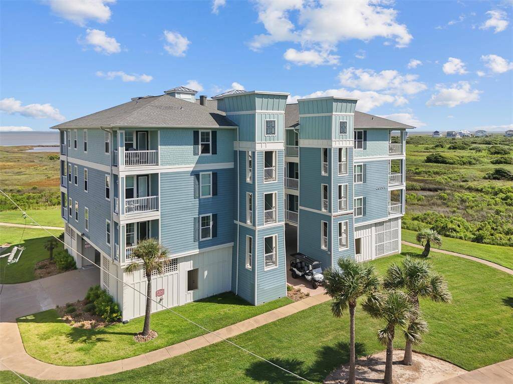 The front view of the Pointe West condo showcases its attractive exterior and spacious balconies. The green landscape and bright exterior colors make the property both inviting and visually appealing.