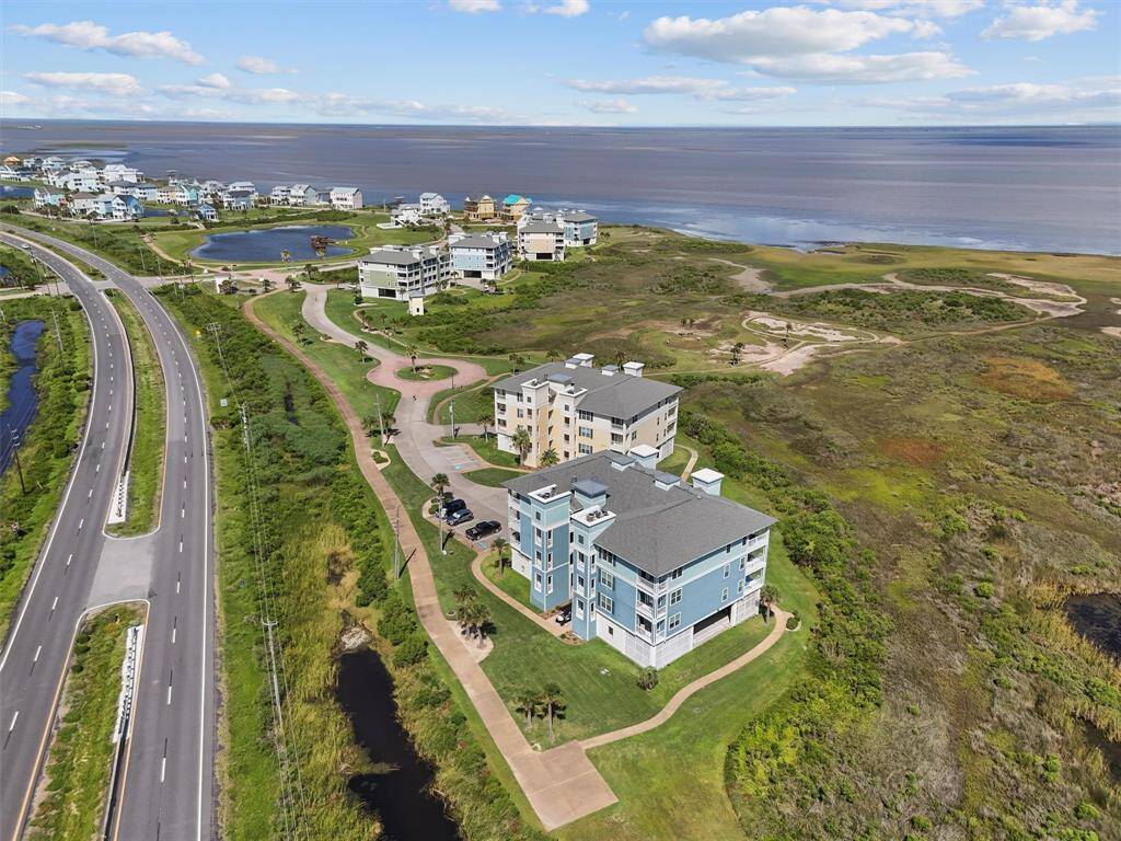 A stunning aerial view of the Pointe West community showcasing the lush green landscape and scenic ocean views. The well-planned layout of the community is evident with the neatly arranged buildings and roadways.