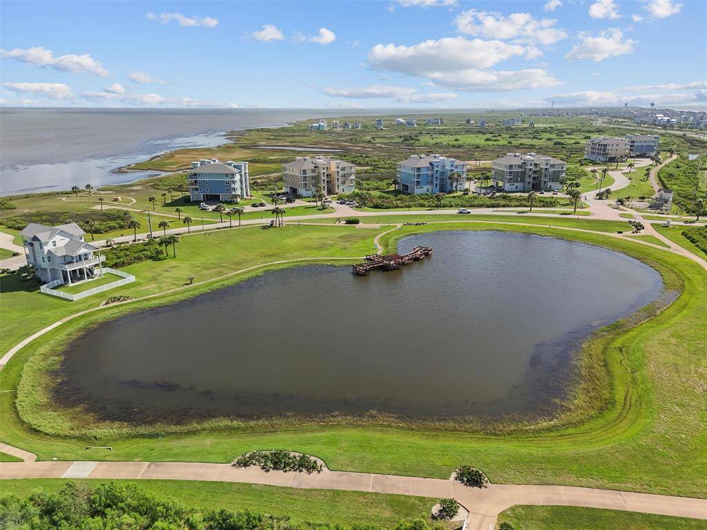 An aerial view of the tranquil pond and lush green surroundings within the Pointe West community. The well-manicured landscapes and nearby ocean create a perfect blend of natural beauty and community living.