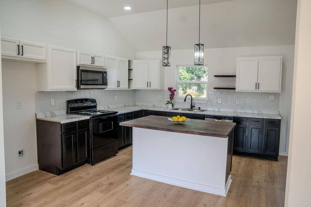 Stylish kitchen with modern cabinetry, sleek countertops, and a new range, dishwasher, and microwave! A perfect space for cooking and entertaining.