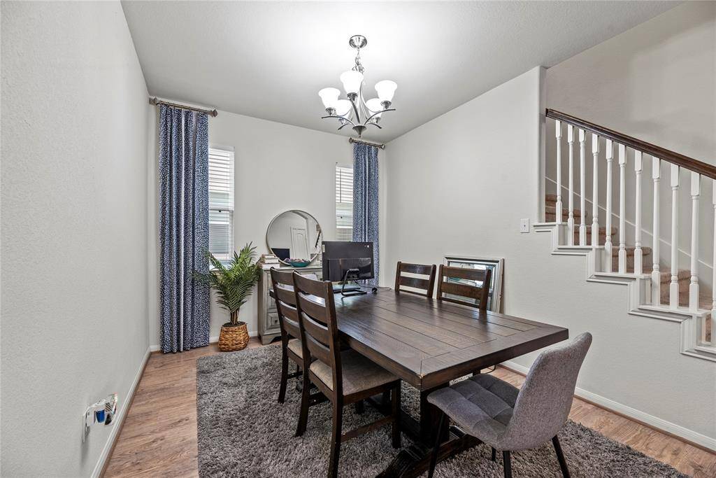 The formal dining area is ideal for a full-sized table and features easy care flooring, bright windows, and an overhead chandelier.