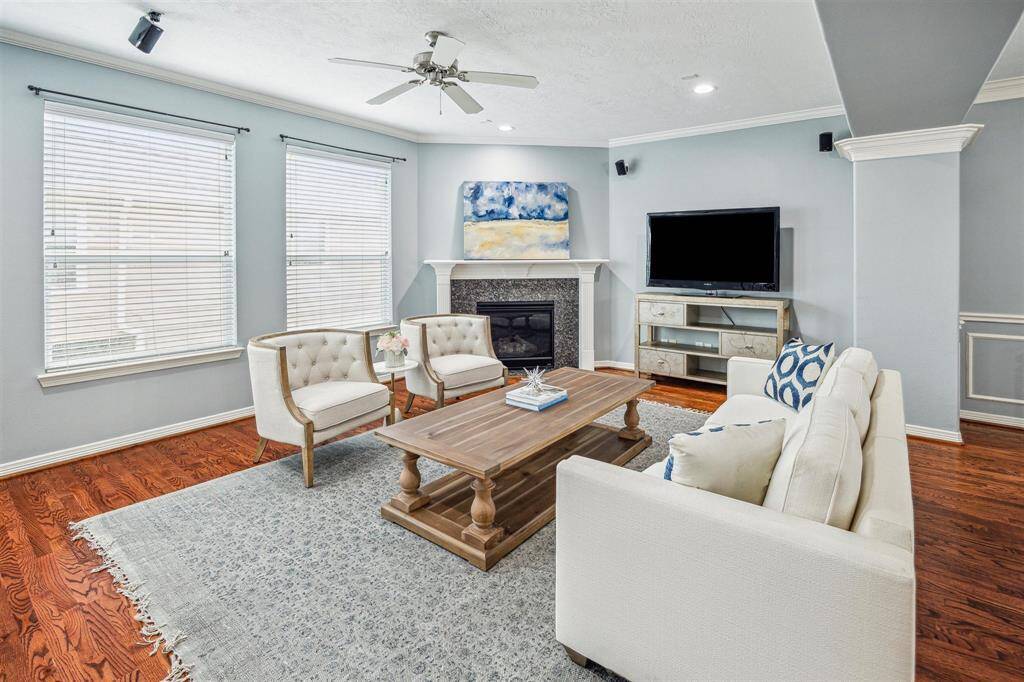 Spacious and bright open floorplan with hardwood floors, recessed listing, crown molding, and ceiling fan.
