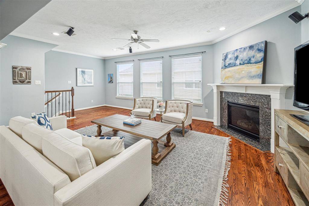 The living room with a gaslog fireplace and large windows with blinds.