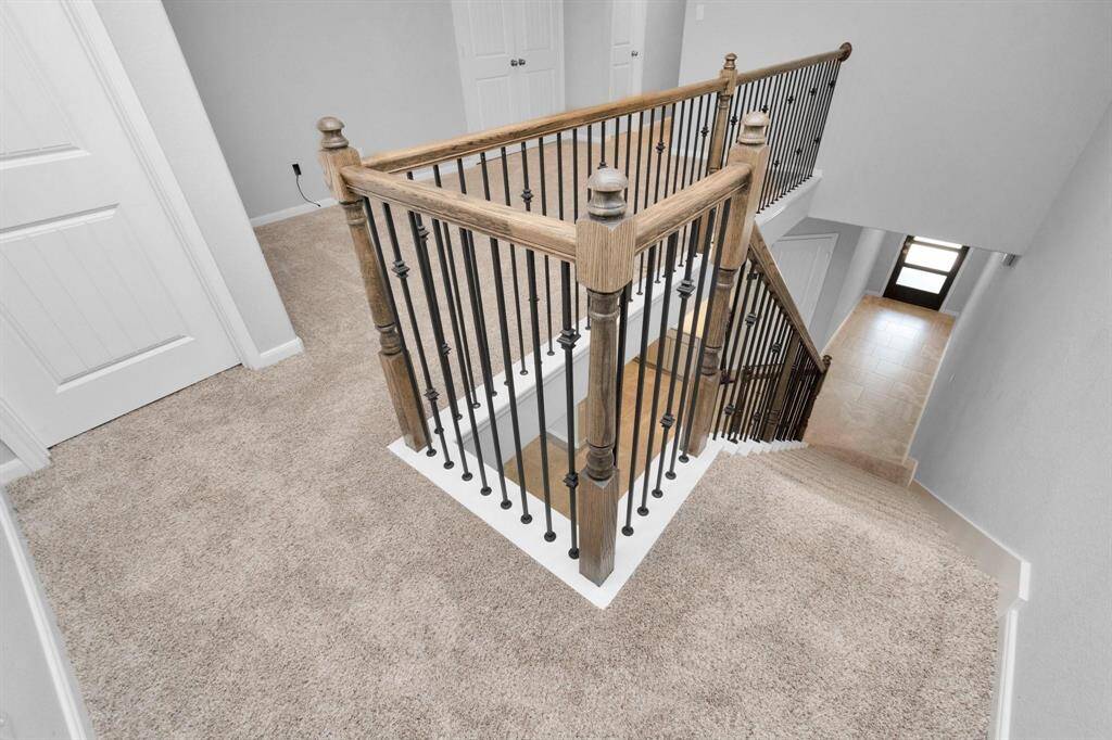 Top of stairs looking at Primary bedroom on the left and the game room on the right as well as the doors to the utility room