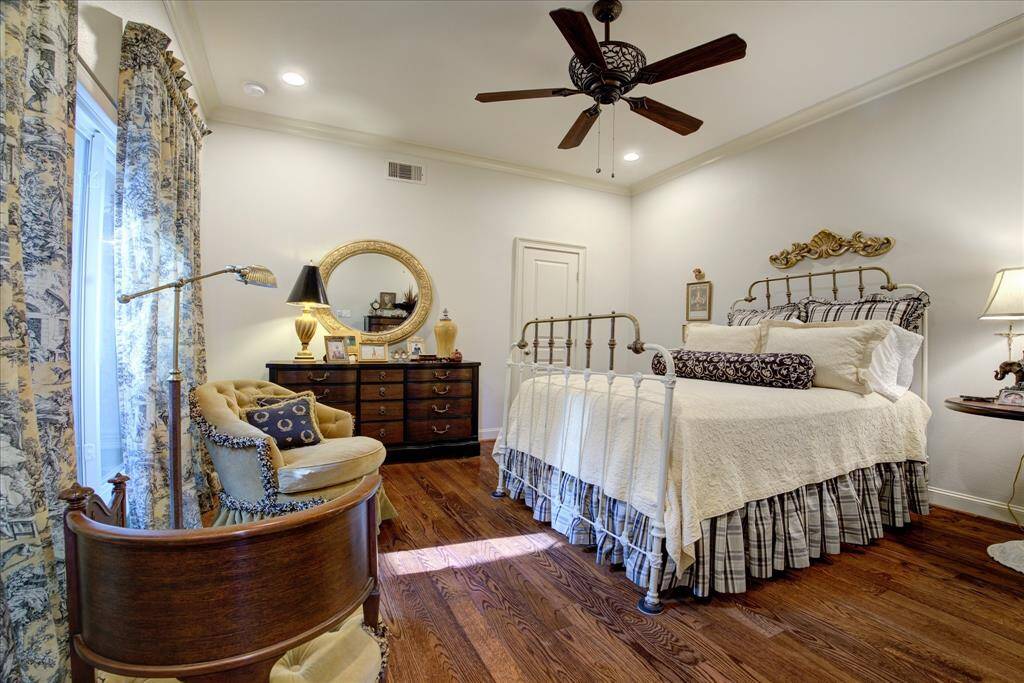 This secondary bedroom has a large walk-in closet, black out shades, hardwood floors and ceiling fan.