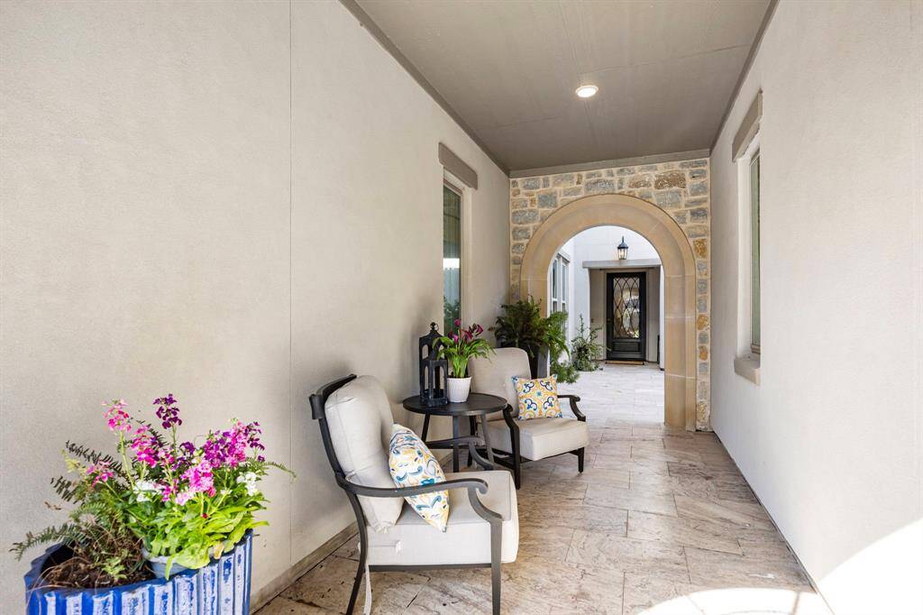 This inviting home feature showcases a cozy outdoor seating area courtyard with zoned speaker system and outdoor TV.