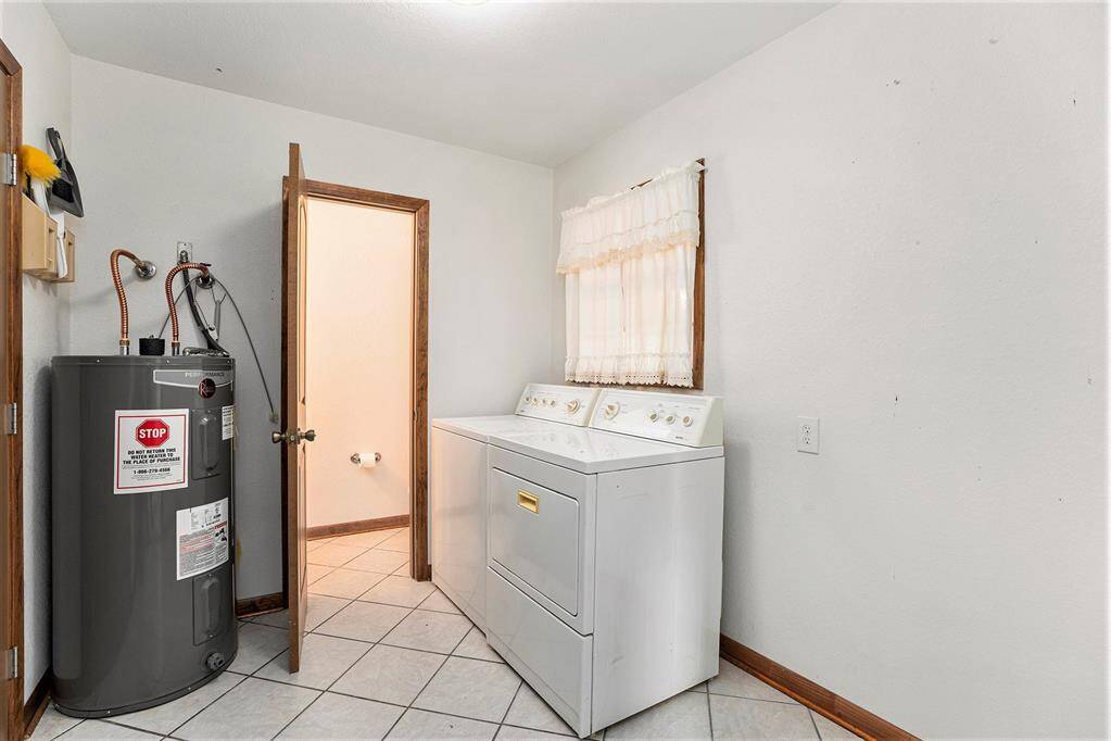Convenient utility room with easy water heater access and a nearby half bath.