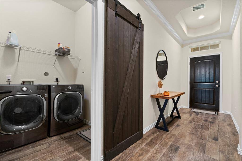 A modern barn door leads into the laundry room.