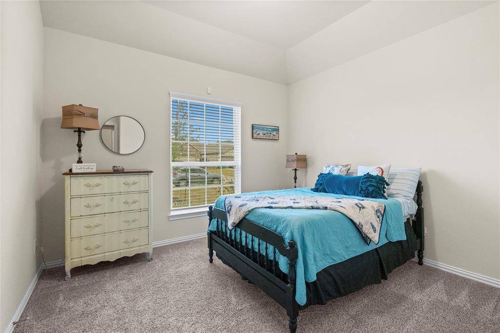 Cozy bedroom with carpeted flooring and neutral walls.