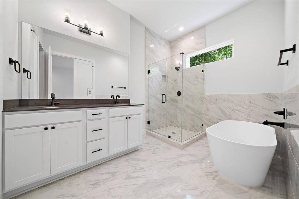 Primary bathroom features double-sink, soft close cabinets, large soaking tub and stand-up shower.