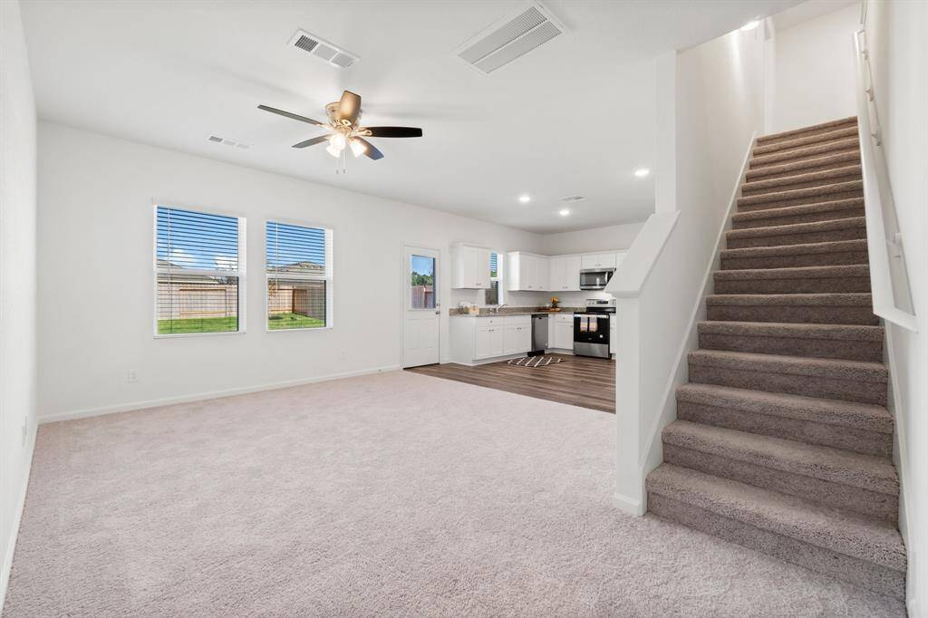 Another view of the family room and kitchen and staircase leading to the upstairs.