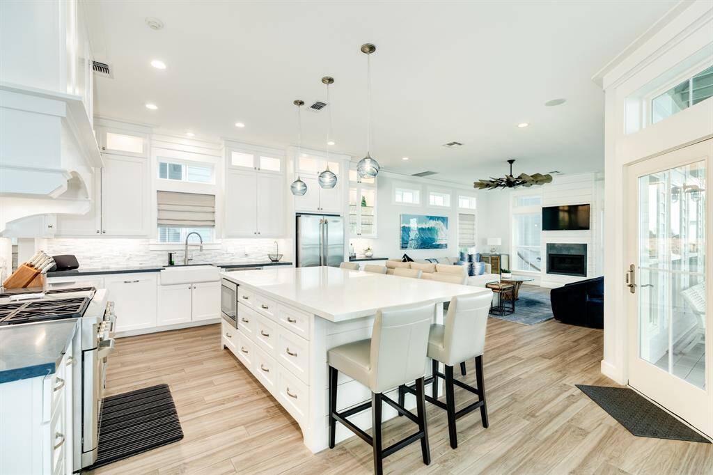The island will seat 6 guest - friends and family.  Perfect for large or small entertaining.  Beautifully colored pendant lights give a coastal feel to the kitchen.