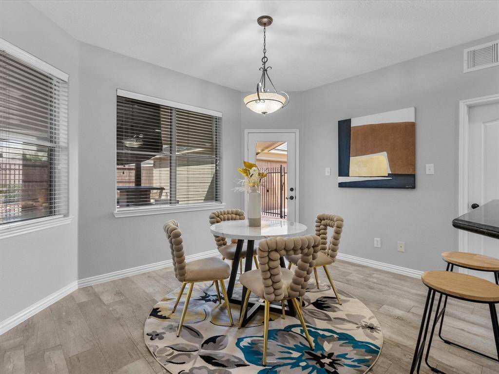 Bright breakfast area with panoramic windows and backyard views.