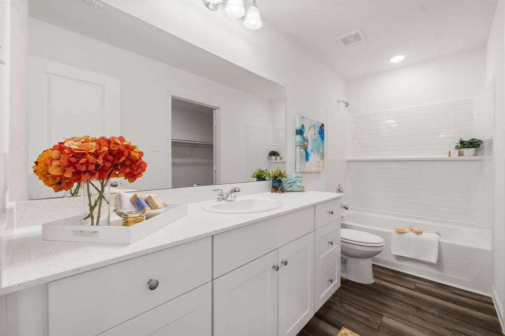 Experience luxury and convenience in your primary bathroom, featuring stunning quartz countertops that combine elegance with durability.