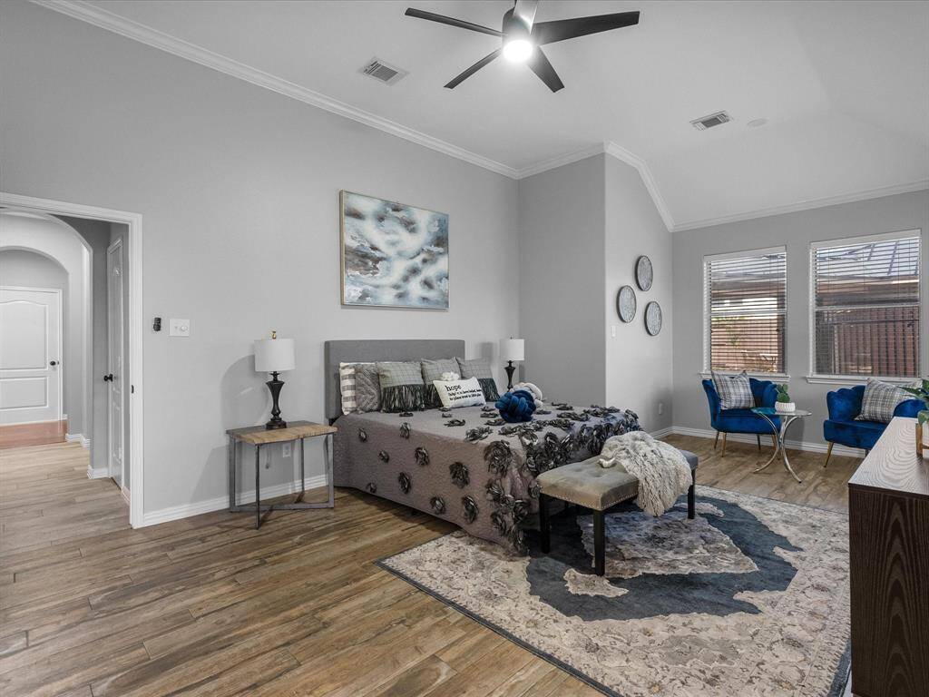 Primary suite offering a cozy seating area and large windows for natural light.