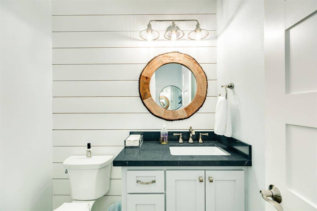 Half-bath on the first living level with a modern shiplap feature.