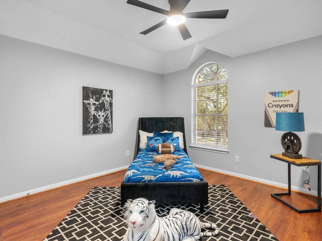 Spacious bedroom with vaulted ceilings and an arched window for abundant natural light