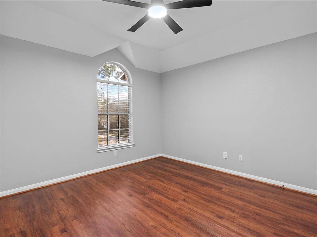 Additional bedroom with a large arched window allowing natural light to flow in